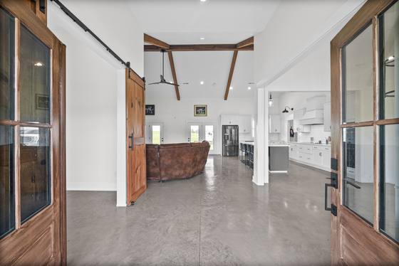 Open living, dining and kitchen under vaulted ceilings