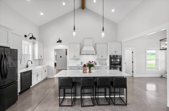 Kitchen with oversized island, vent hood and double wall ovens