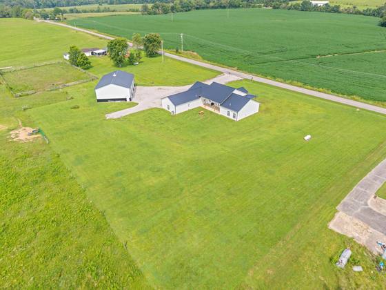 Aerial over the homestead — shop, both homes and open pasture