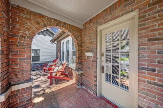 Arched brick openings frame the porch