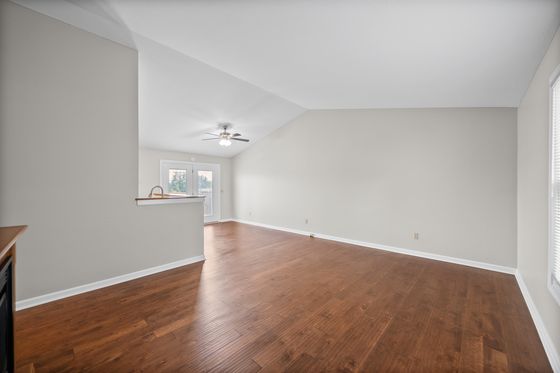 Open living room with vaulted ceiling and wood-look flooring