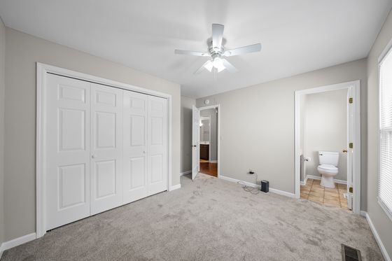 Primary bedroom with double closet and private half bath