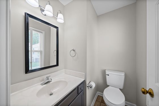 Private half bath with vanity and toilet