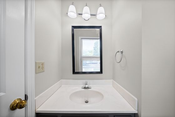 Half bath vanity with framed mirror and window