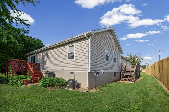 Rear elevation of the home with deck and central air unit