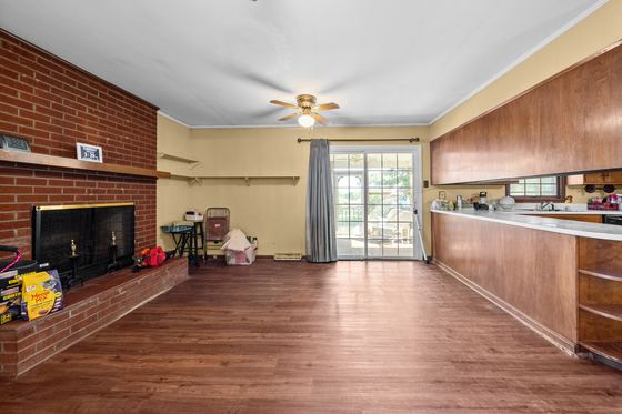 The den - full brick fireplace wall, open to the kitchen, door out to the back, 5525 Glass Lane